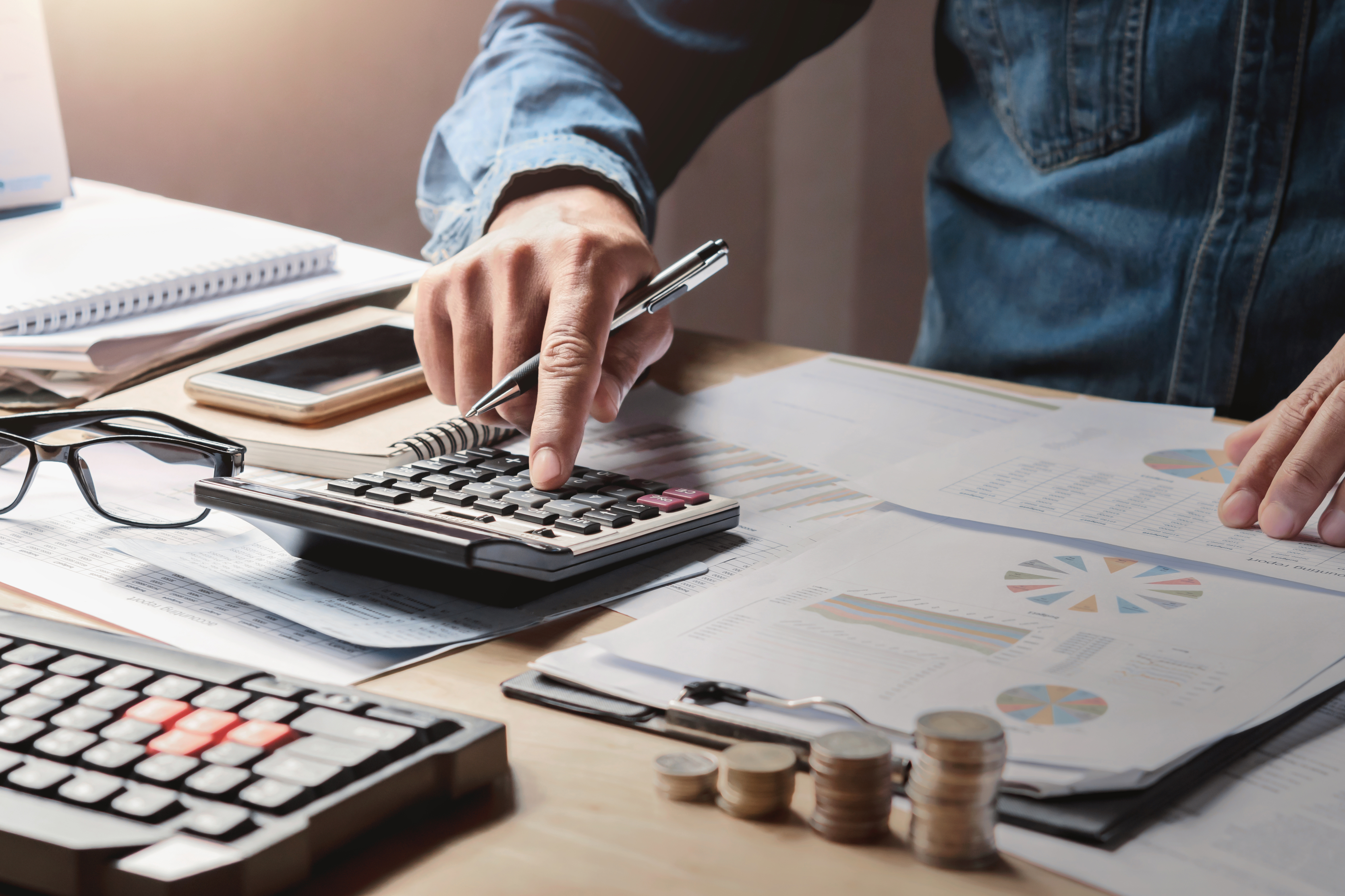 Man using a calculator while looking at financial documents