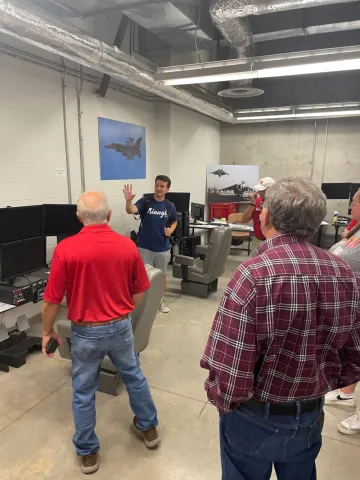 Council members hear about the flight simulators during the Aerospace Adventures tour.