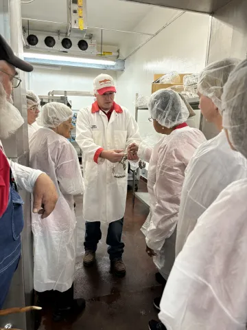 Terry Houser, Associate Professor at the ISU Meat Lab, shows tour participants casings made from cotton by-products.