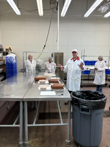 Participants learn about the evaluation of meat products that have been processed using different equipment (samples are on the table)..